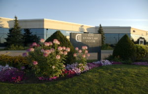 A large garden with many different flowers and perfectly trimmed bushes. A sign in the middle reads "1155 Ennisclare Centre"