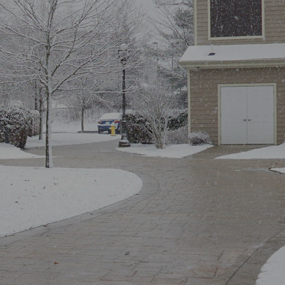 Beautiful landscaped interlocked driveways and roads with snow covered grass